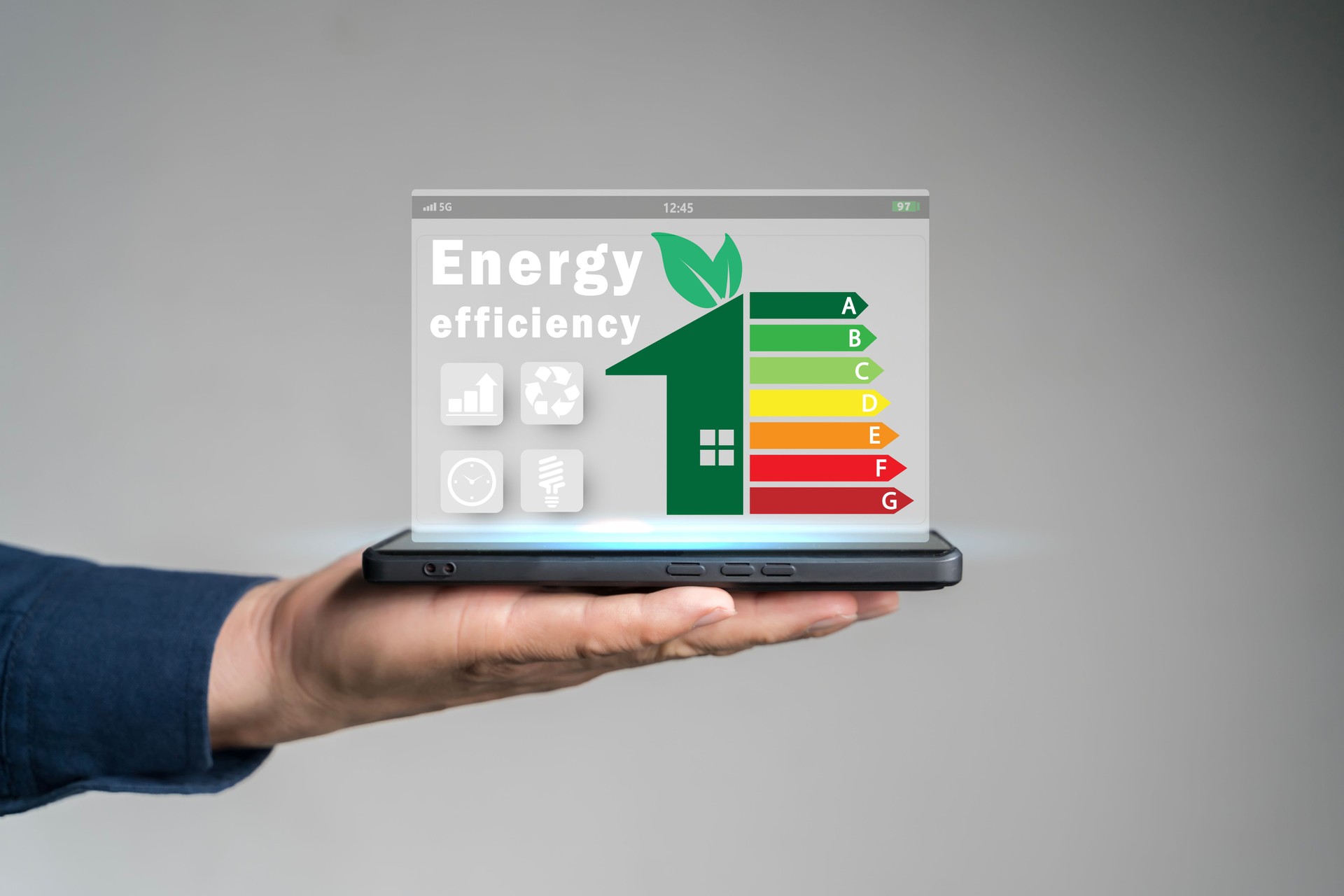 Energy efficiency concept. Person using tablet with energy efficiency rating icon on virtual screen for energy efficient house.